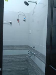 a shower with two shower heads in a bathroom at galaxy hotel jobner in Jobner