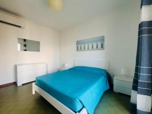 a bedroom with a blue bed and white walls at Onda blu in Marina Julia