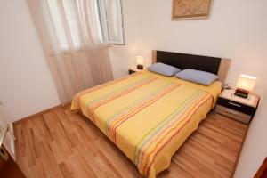 a bedroom with a bed with two pillows on it at Apartment Miljenko Tomić in Splitska