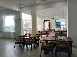a dining room with wooden tables and chairs at galaxy hotel jobner in Jobner