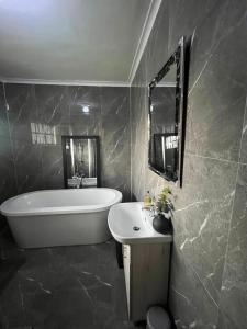 a bathroom with a bath tub and a sink at The Savannah Escape in Norton +19 photos