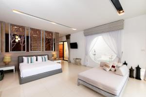 a bedroom with two beds and a couch at Cae Villa Hua Hin in Hua Hin +34 photos