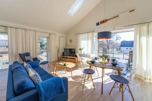 a living room with a blue couch and a table at SEASIDE APARTMENTS - BEACHHOUSE SKY in Eckernförde