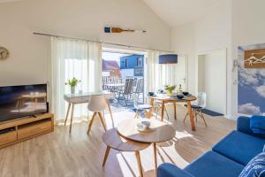 a living room with a blue couch and a table at SEASIDE APARTMENTS - BEACHHOUSE SKY in Eckernförde +7 photos