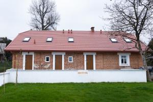 a brick house with a red roof at Starowiejska Residence 1860 in Miejsce Piastowe