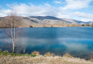 a large blue lake with mountains in the background at Twizel getaway in Twizel +4 photos