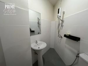 a white bathroom with a sink and a mirror at Prime Silom in Bangkok