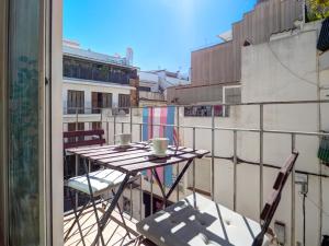 Ein Tisch auf einem Balkon mit zwei Tassen und Stühlen in der Unterkunft Bonaire Apartment by Hello Homes Sitges in Sitges
