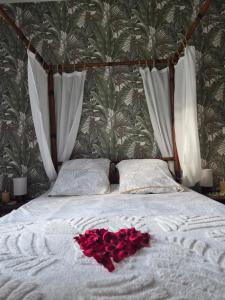 a bed with a bunch of red roses on it at Suite Eden Jungle - Ambiance tropicale cosy in Limoges