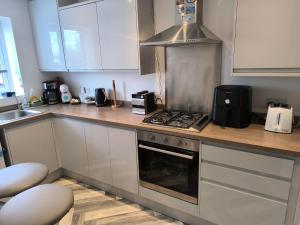 a kitchen with white cabinets and a stove top oven at Teddy's in Immingham