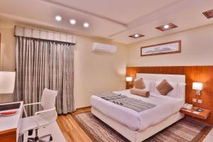 a bedroom with a large white bed and a desk at Avari Xpress Faisalabad in Faisalabad +37 photos
