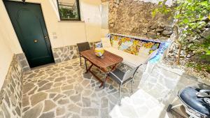 a wooden table and chairs in front of a door at Sea View Apartments Amalfi Coast by Amalfi Coast with Locals in Conca dei Marini