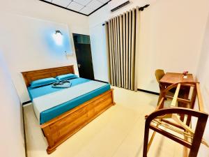 a bedroom with a bed and a wooden chair at Kings Garden House in Weligama