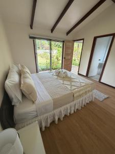 a bedroom with a large bed with a large window at Cabañas Anariki in Hanga Roa