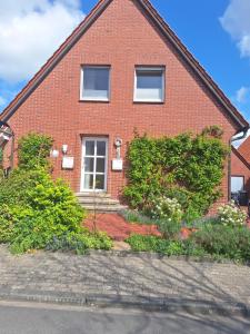 a red brick house with bushes in front of it at Fewo Holtwicker Ei in Rosendahl