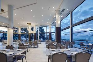ein Restaurant mit Tischen und Stühlen und großen Fenstern in der Unterkunft Waveside hotel in Altınordu