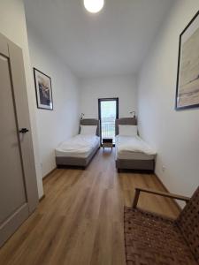 a room with three beds in a room at Rewal Komfortowy Apartament 2 Sypialnie 10 min od Plaży Parking Taras Grill in Rewal