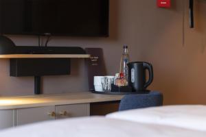 a room with a table with a coffee maker and a bottle at Scandic Stuttgart Europaviertel in Stuttgart