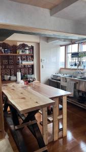 a kitchen with a wooden table in a kitchen at ゲストハウス のまー in Komagane