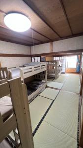 an empty room with a bed and chairs in it at ゲストハウス のまー in Komagane +5 photos
