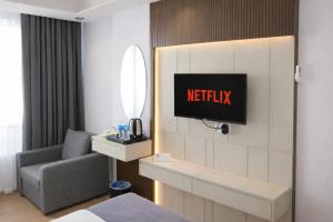 a hotel room with a couch and a tv on a wall at Casa Ayris Boutique Hotel in Mersin