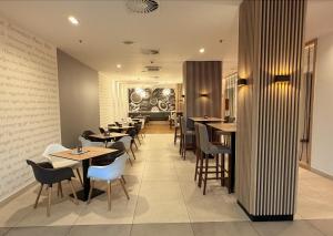 a restaurant with tables and chairs in a room at Tóth Wellness Apartman in Zalakaros