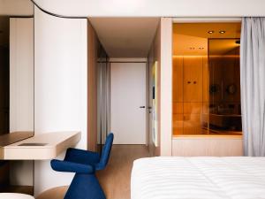 a blue chair in a bedroom with a desk at Boutique Hotel Venturo, a Member of Design Hotels in Split
