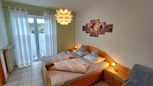 a small bedroom with a bed with a chandelier at Fischerhof Agriturismo in Cornaiano