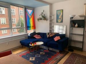 a living room with a blue couch and a window at Studio apartment by the metro in Copenhagen
