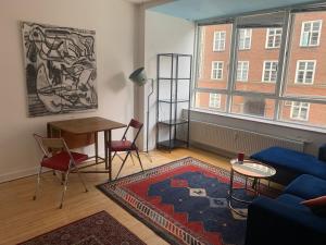 a living room with a couch and a table at Studio apartment by the metro in Copenhagen