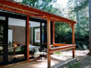a pavilion with a table and a chair on a deck at Outdoors Holten - Forest Cabin in Holten