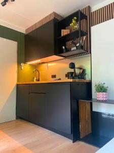 a kitchen with black cabinets and a counter at Outdoors Holten - Forest Cabin in Holten