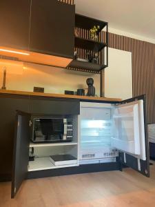 an open refrigerator in a kitchen with its door open at Outdoors Holten - Forest Cabin in Holten +2 photos
