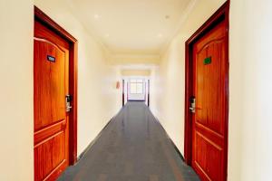 an empty hallway with two wooden doors and a hallway at OYO Townhouse Anantapur Near Srikantam Circle in Anantapur