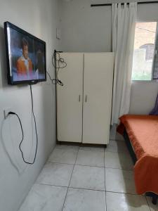 a living room with a tv on a wall at Kitnet quarto e cozinha ha 3min da Unifesp in São Paulo