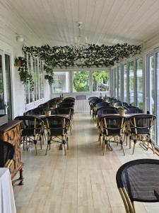 a dining room with chairs and tables and windows at Skotteksgarden Lakefront Cottages and Camping near Ulricehamn in Ulricehamn