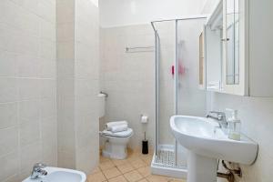 a white bathroom with a sink and a toilet at Residence Argentiera in Miniera dellʼArgentiera