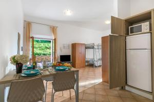 a kitchen and dining room with a table and a refrigerator at Residence Argentiera in Miniera dellʼArgentiera