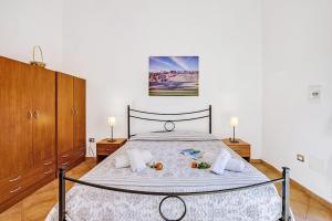 a bedroom with a large bed with two night stands at Residence Argentiera in Miniera dellʼArgentiera