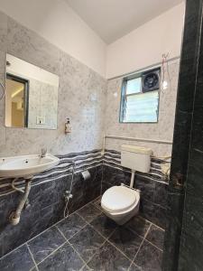 a bathroom with a toilet and a sink at The Royal Samrat Newly renovated in Pune