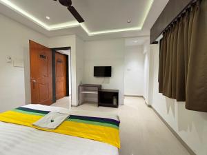 a bedroom with a large bed and a television at The Royal Samrat Newly renovated in Pune