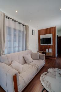 a living room with a white couch and a television at Mayas Stay in Busia