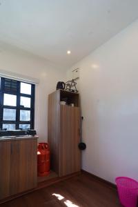 a kitchen with a wooden cabinet and a window at Mayas Stay in Busia