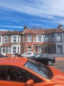 two cars parked in a parking lot in front of houses at Dominic's Home in Seven Kings
