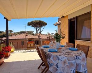a patio with a table with blue plates on it at LE TERRAZZE Apartment - spacious and charming apartment near the sea and beach, close to the train station with hourly trains to Rome - Lido delle Sirene, Anzio in Anzio
