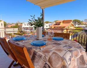 a table with blue plates and glasses on a balcony at LE TERRAZZE Apartment - spacious and charming apartment near the sea and beach, close to the train station with hourly trains to Rome - Lido delle Sirene, Anzio in Anzio