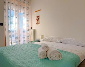 a bedroom with a bed with towels on it at LE TERRAZZE Apartment - spacious and charming apartment near the sea and beach, close to the train station with hourly trains to Rome - Lido delle Sirene, Anzio in Anzio