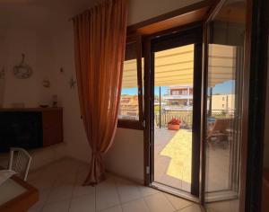 a kitchen with a sliding glass door to a patio at LE TERRAZZE Apartment - spacious and charming apartment near the sea and beach, close to the train station with hourly trains to Rome - Lido delle Sirene, Anzio in Anzio