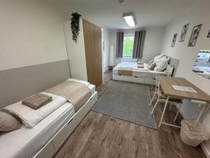 a room with two beds and a table and a couch at Hostel by BookieBooking in Wiesbaden