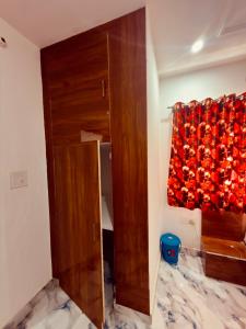a room with a wooden door and a curtain at Shri charno amrit vatika in Vrindāvan